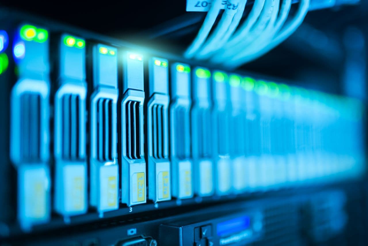 Image of a server rack with glowing lights in a modern data center.